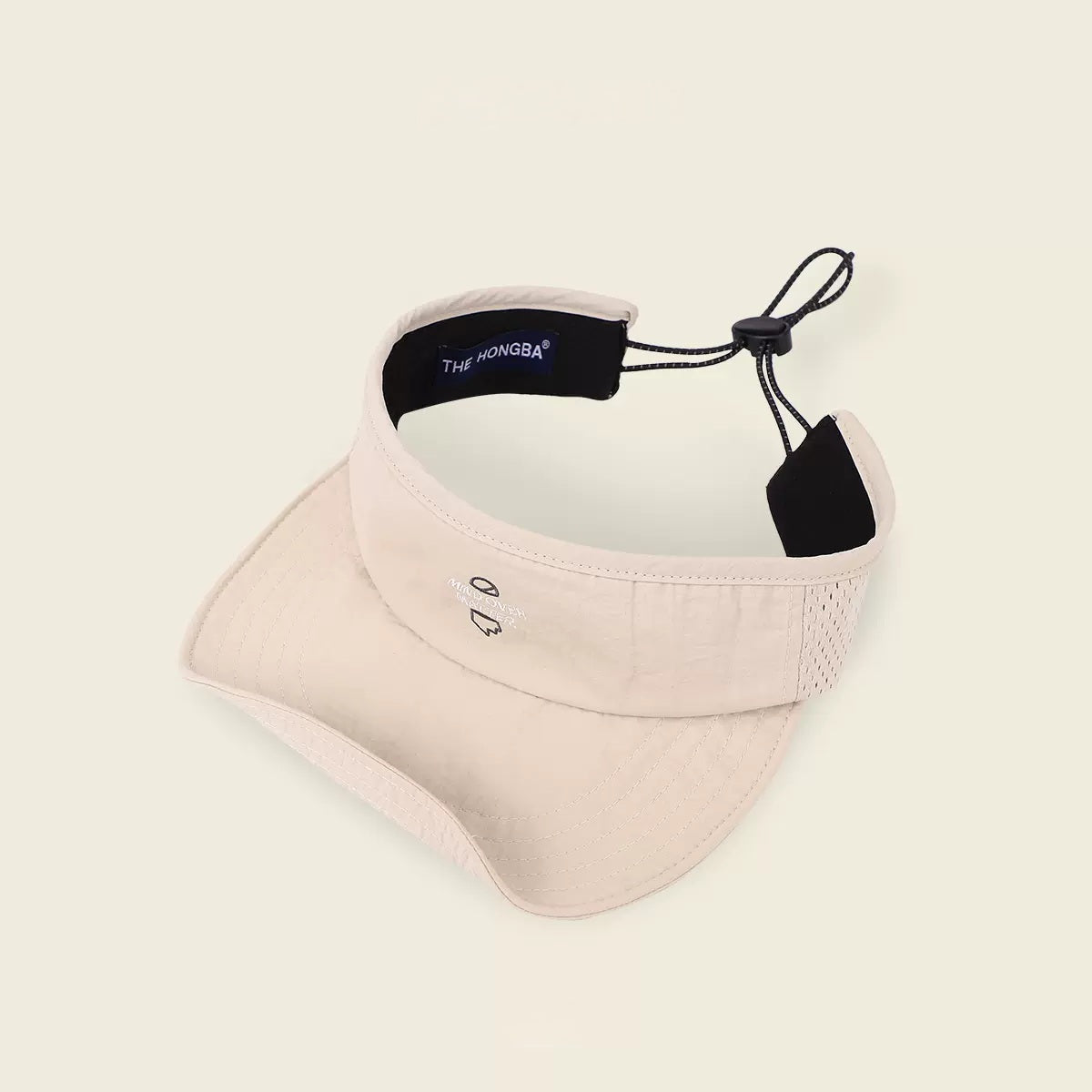 Beige visor cap with black strap on a light beige background