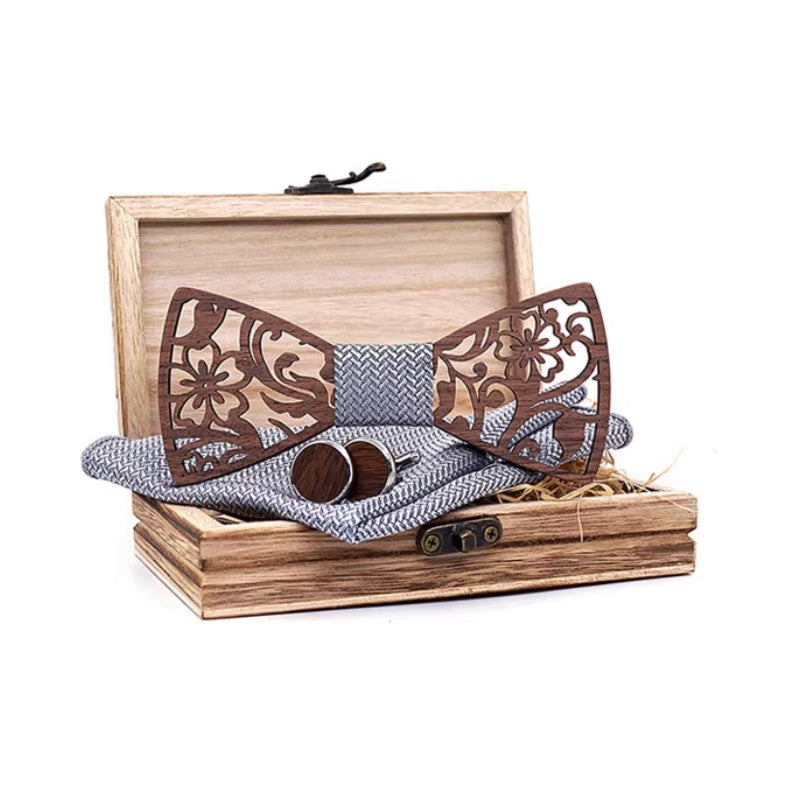 Wooden bow tie set with decorative patterns in a wooden box on a white background