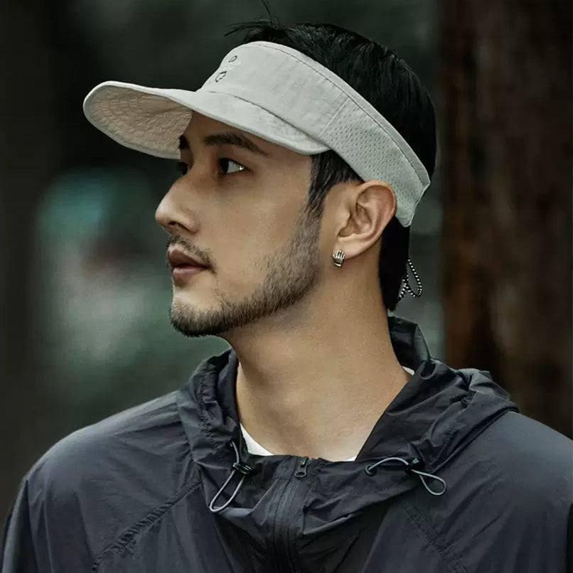 Man wearing a cap and dark jacket outdoors
