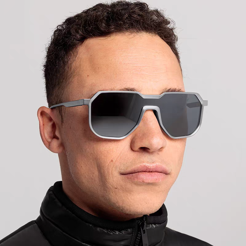 Man wearing futuristic sunglasses against a plain background