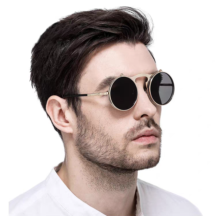 Man wearing round sunglasses with gold frame and black lenses on a white background