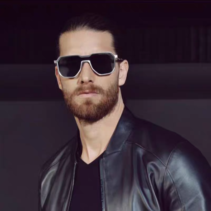 Man wearing sunglasses and a black leather jacket against a dark background