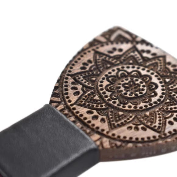 Wooden spatula with intricate mandala design on a white background