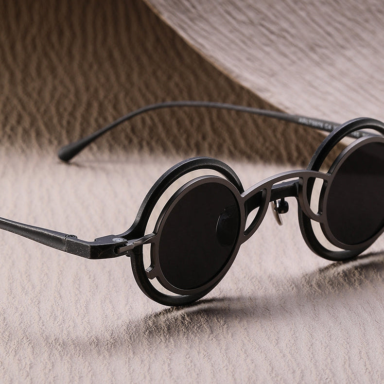 Round sunglasses with black frames on a textured beige background