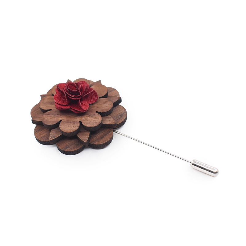 Wooden flower lapel pin with a red center on a white background