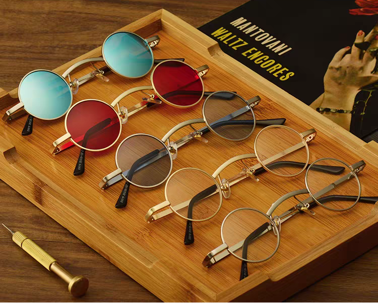 Collection of eyeglasses on a wooden tray with a book in the background