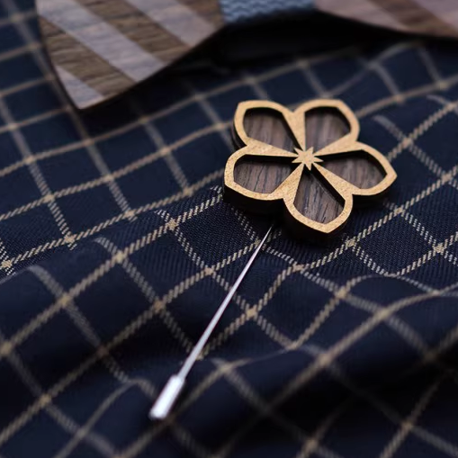 Gold floral lapel pin on a dark blue checkered shirt