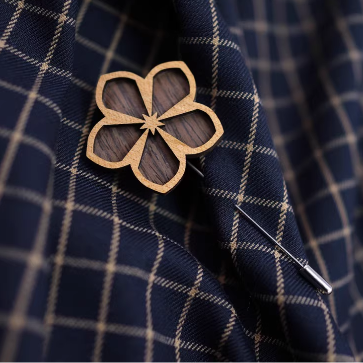 Wooden flower-shaped brooch on a navy plaid fabric