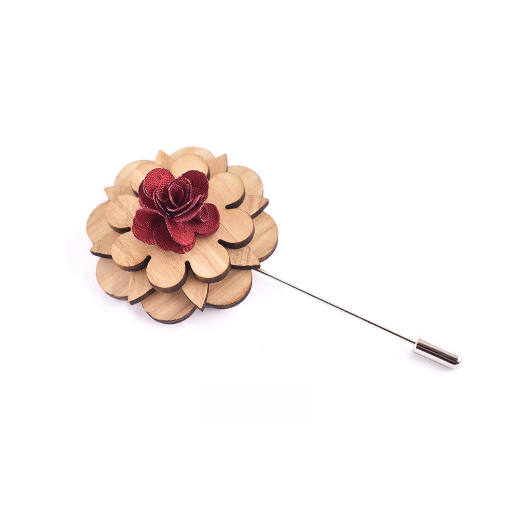 Floral lapel pin with wooden petals and red center on a white background