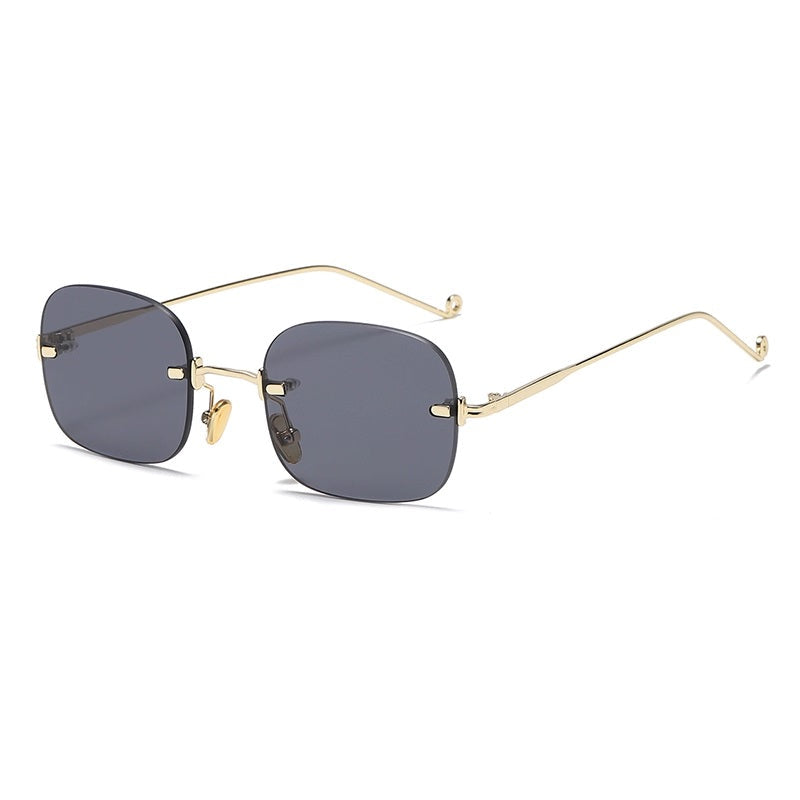 Sunglasses with gold frame and dark lenses on a white background