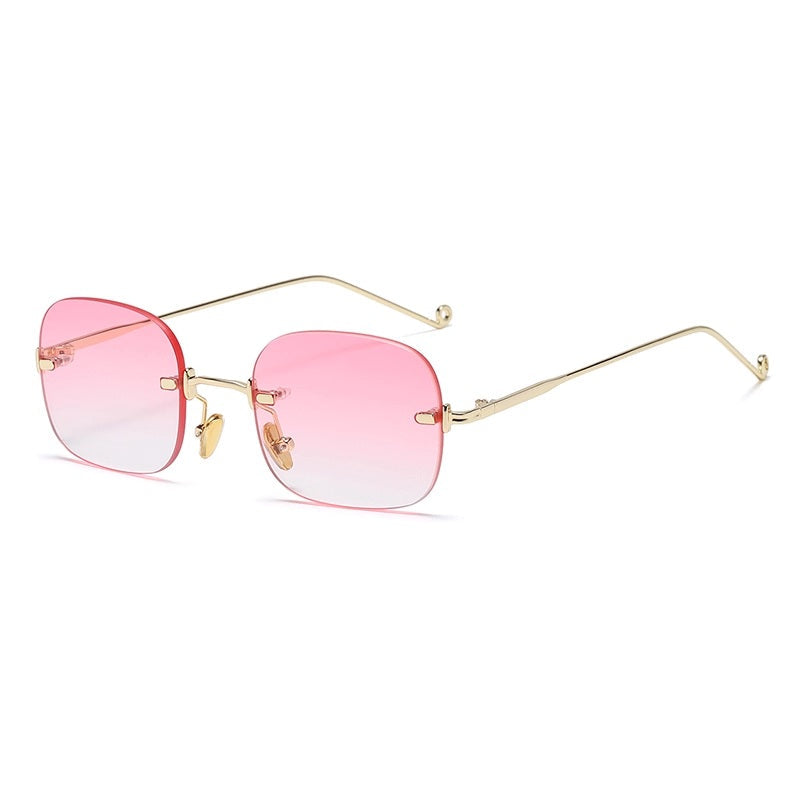 Sunglasses with pink gradient lenses and gold frame on a white background