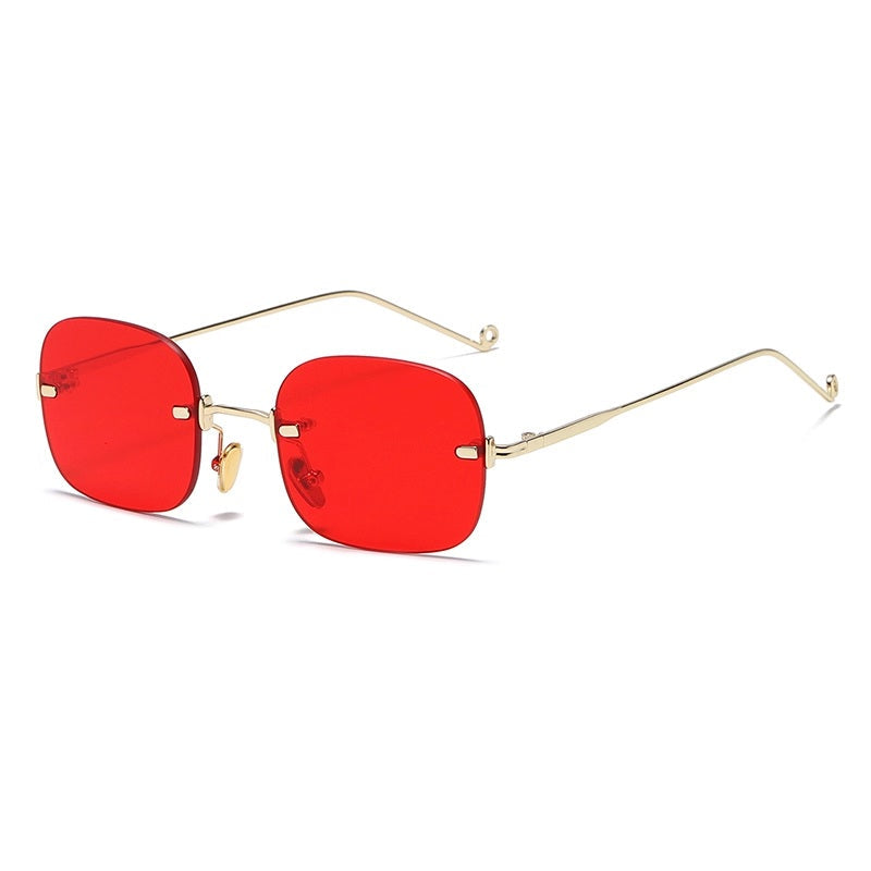 Sunglasses with red lenses and gold frames on a white background