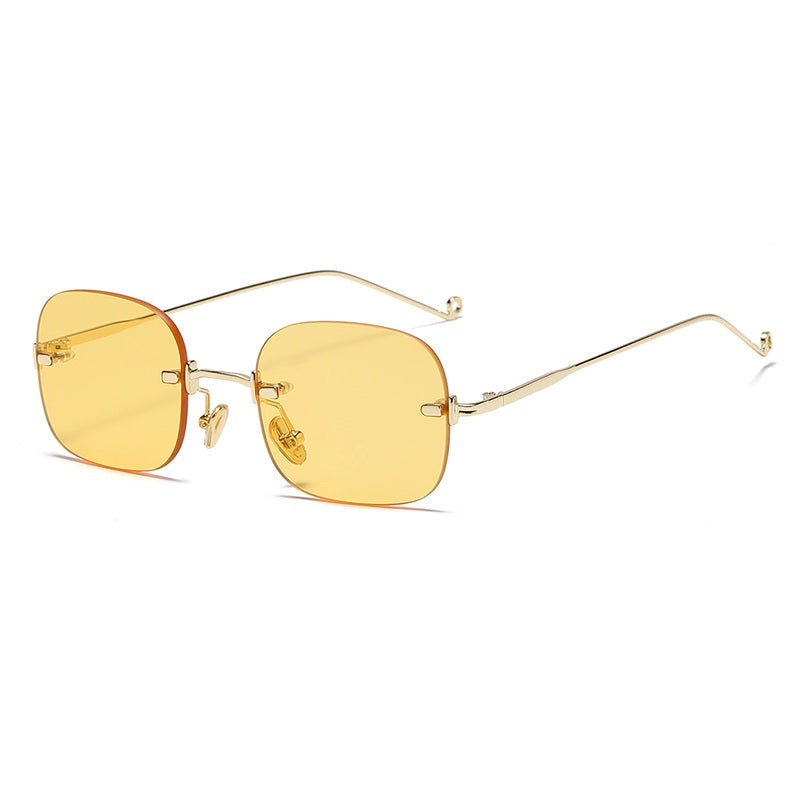Gold-framed sunglasses with yellow lenses on a white background