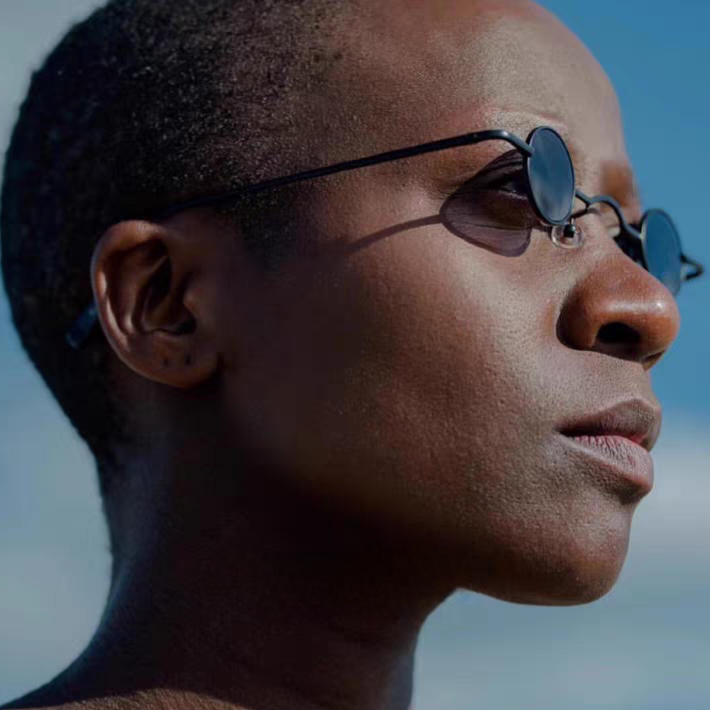 Close-up of a person wearing sunglasses with a blurred background