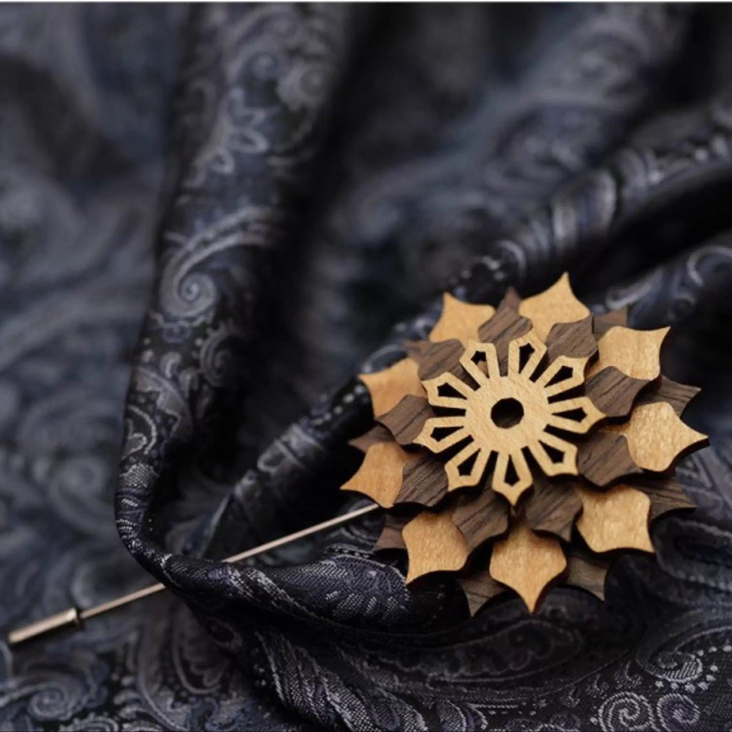 Wooden brooch on dark fabric with text indicating available styles.