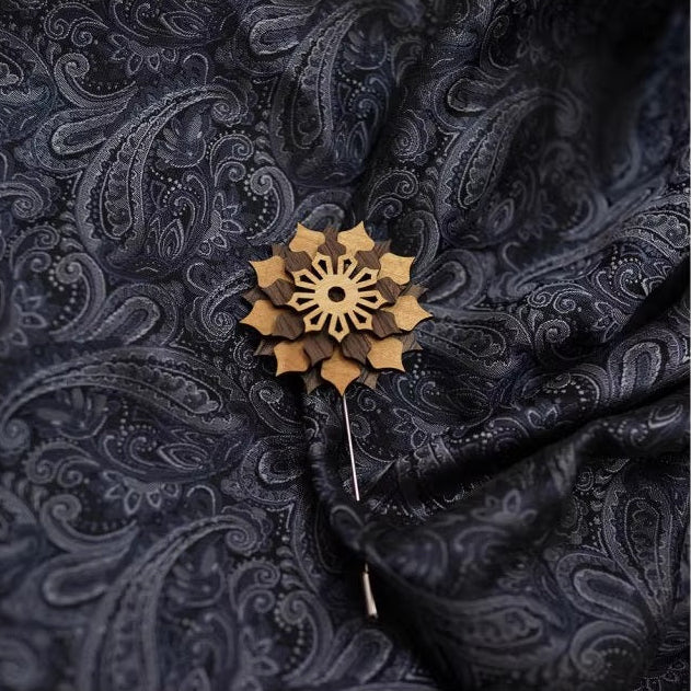 Decorative brooch on a dark patterned fabric background