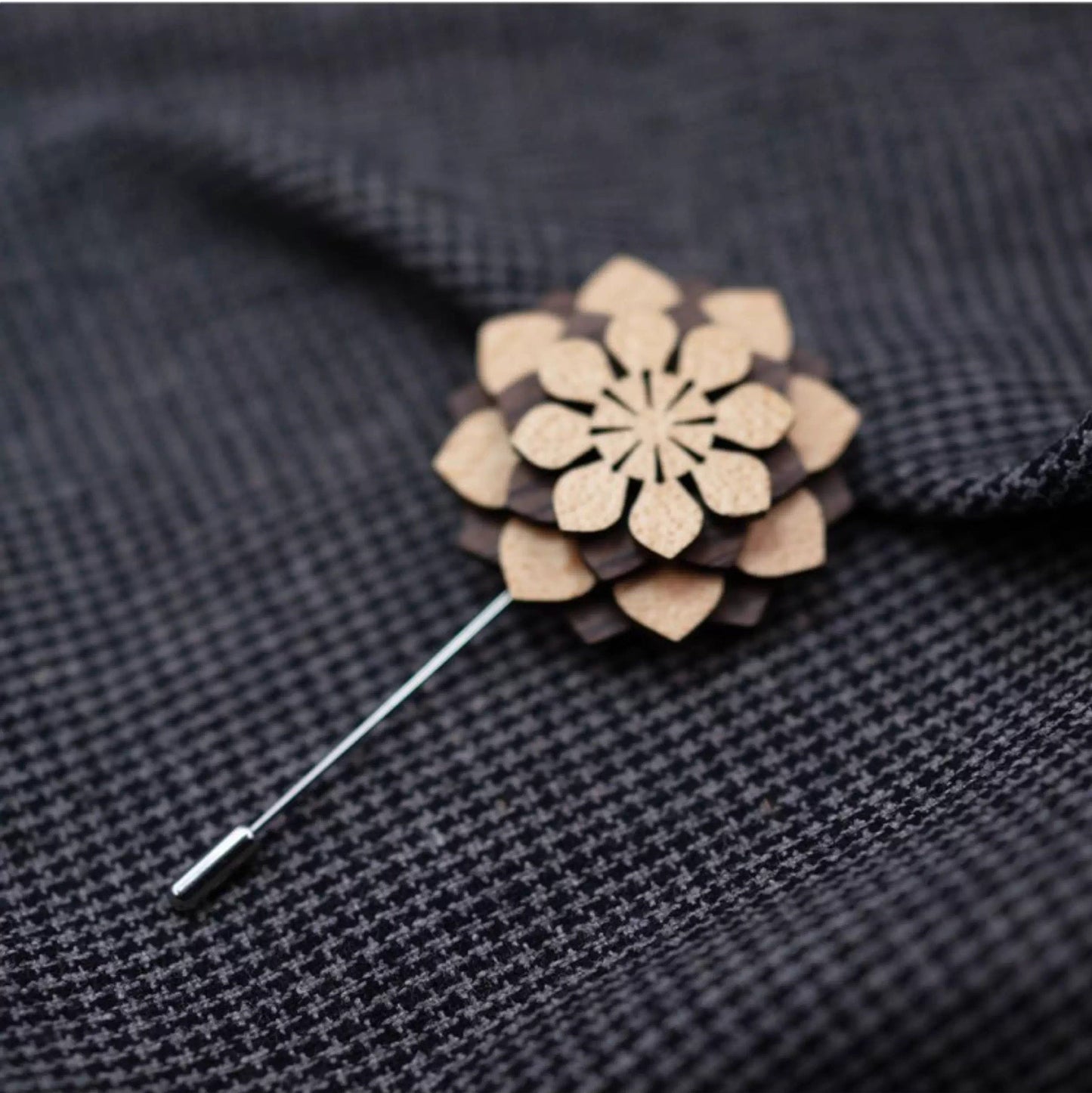 Wooden flower-shaped brooch on a dark fabric background