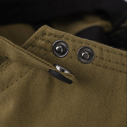 Close-up of a brown fabric with buttons and a brand logo on the left.