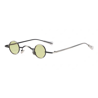 Round sunglasses with thin metal frame and green lenses on a white background.