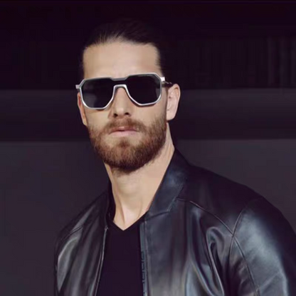 Man wearing sunglasses and a black leather jacket against a dark background
